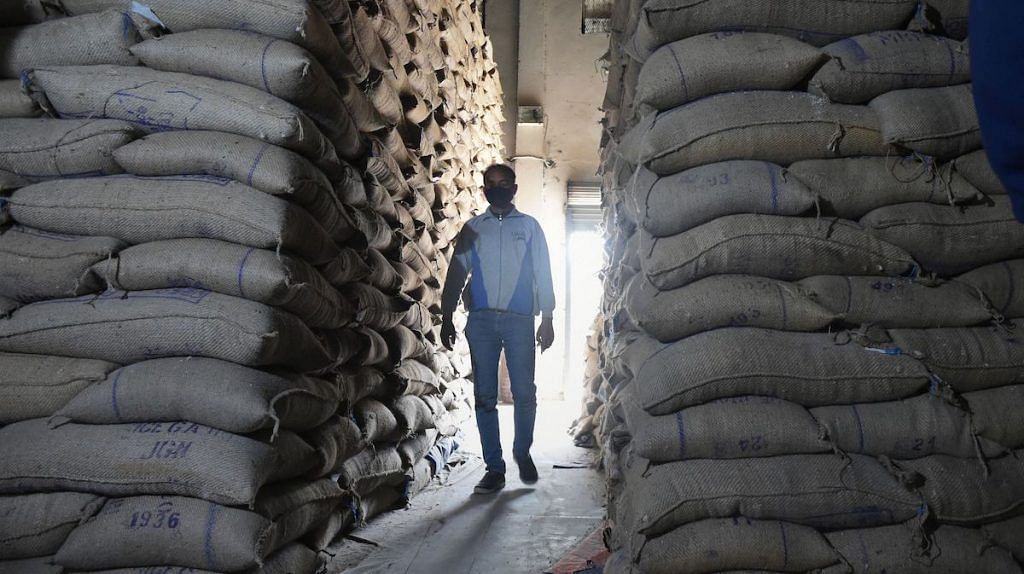 File photo | An employee inspects a godown of Food Corporation of India (FCI) where rice bags are being stored during a nationwide lockdown, in Srinagar | PTI