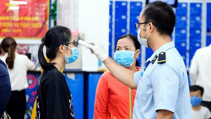 Customers have their temperature checked at the entrace to a Co.opmart supermarket during a partial lockdown imposed due to the coronavirus in Ho Chi Minh City, Vietnam. | Photographer: Maika Elan | Bloomberg