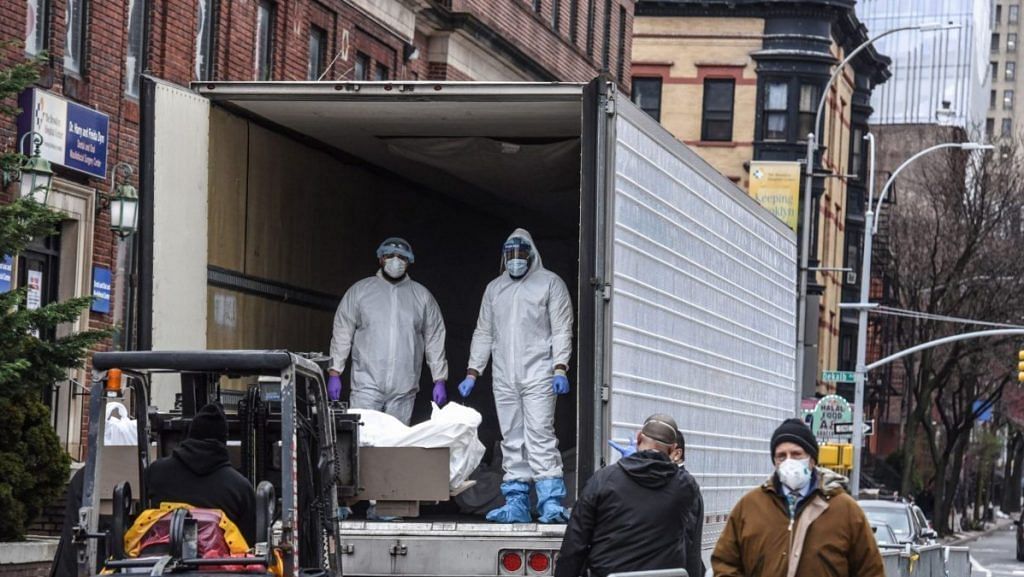 Medical workers remove a body from a refrigerator truck outside of the Brooklyn Hospital in New York on March 31. Photo | Bloomberg