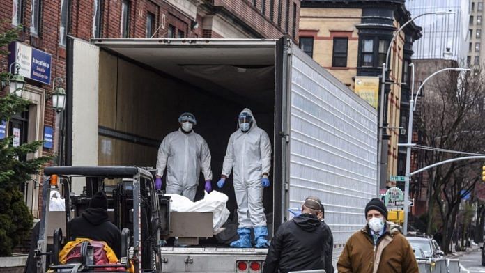 Medical workers remove a body from a refrigerator truck outside of the Brooklyn Hospital in New York on March 31. Photo | Bloomberg