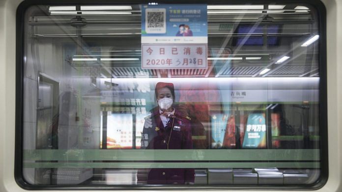 A platform attendant stands on duty at a metro station in Wuhan | Bloomberg