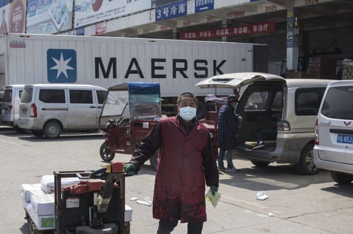A vendor walks with goods at the Baishazhou wet market in Wuhan, April 6. Photo | Bloomberg