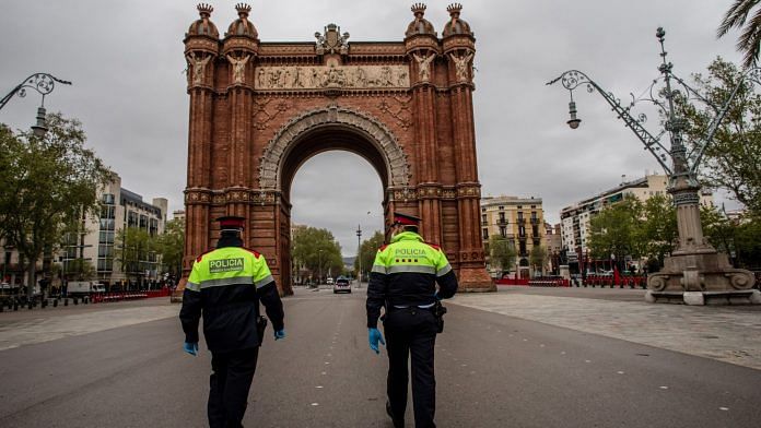 Citizen security officers of the Mossos d'Esquadra police force walk to the Arc de Triomf monument in Barcelona on April 1. | Bloomberg
