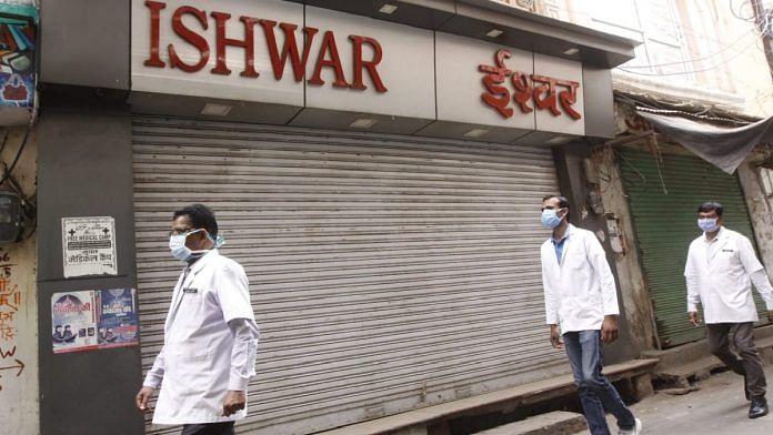 Doctors pass by a store in Khari Khui in Ajmer, the area where the first case Covid-19 was found | Praveen Jain | ThePrint