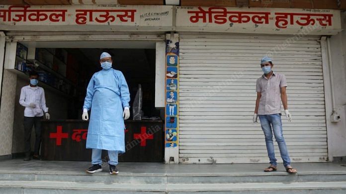 Men in protective gear stand outside a medical store in Bhilwara, Rajasthan, on 27 March | Photo: Manisha Mondal | ThePrint