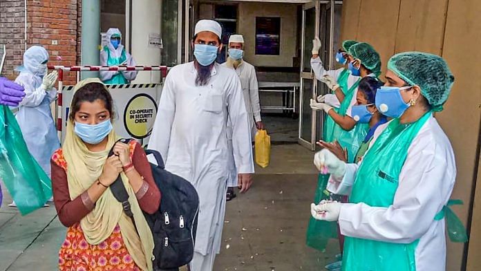 Medical staff shower flower petals on Covid-19 patients who have recovered and are leaving the hospital, in Greater Noida, on 28 April 2020 | PTI