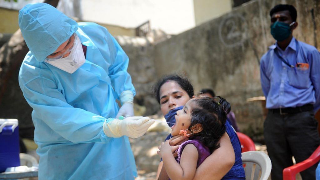 A doctor takes a swab from a child to test for Covid-19 at Kalyanwadi in Dharavi slums, Mumbai on 16 April | PTI