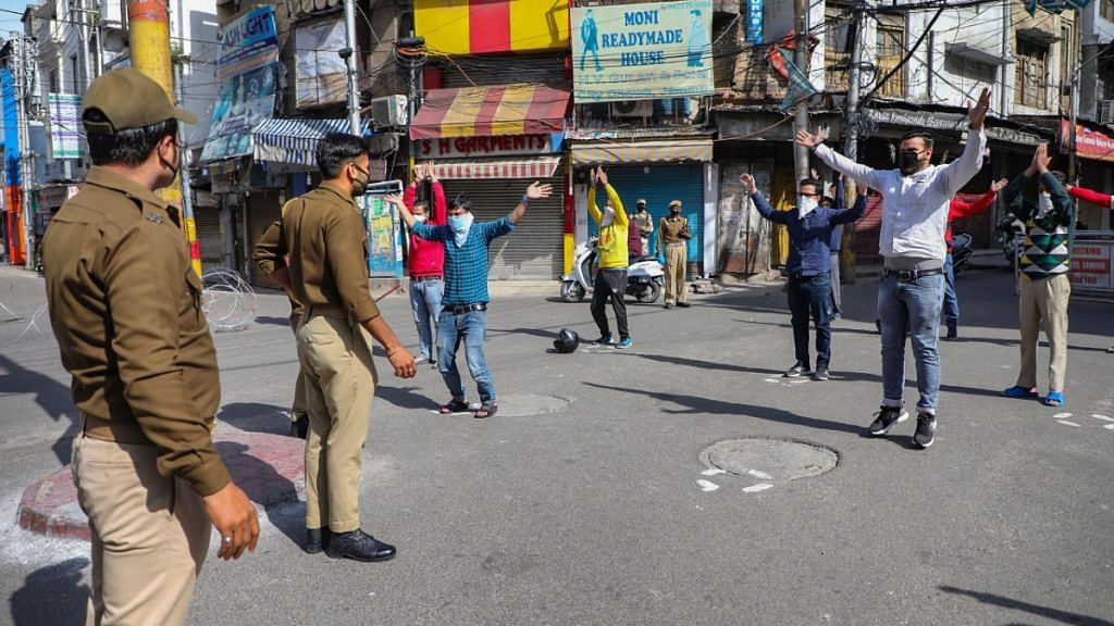 Policemen hold up people flouting the lockdown at City Chowk in Jammu, on 30 March 2020 | PTI