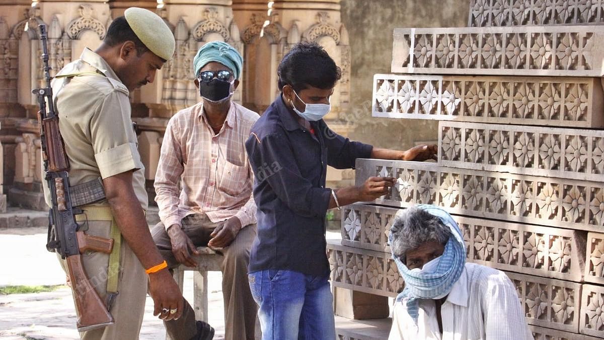 Labourers and a policeman at the Ram Mandir karyashala in Ayodhya Thursday | Photo: Praveen Jain | ThePrint