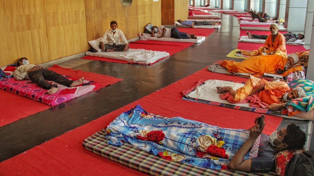 Migrant workers rest inside the Yamuna Sports Complex, which has been converted into a makeshift shelter during the ongoing COVID-19 lockdown, in New Delhi, on 5 April 2020 | PTI