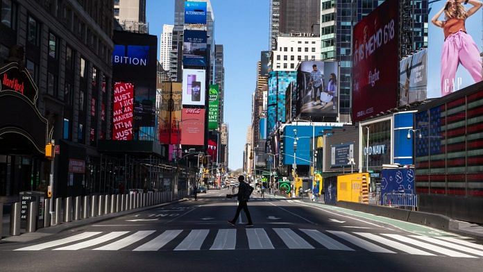 A pedestrian crosses a nearly empty street in the Times Square neighborhood of New York, US | Bloomberg