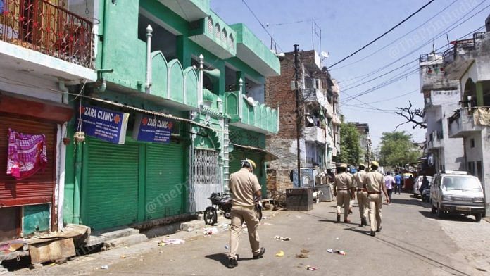 Police personnel walk through a locked down Sadar Bazar area where 12 new cases of coronavirus were reported | Praveen Jain | ThePrint
