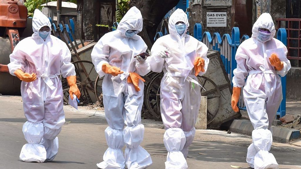 Health workers wearing protective suits walk on a street in Kolkata | Representational image | PTI