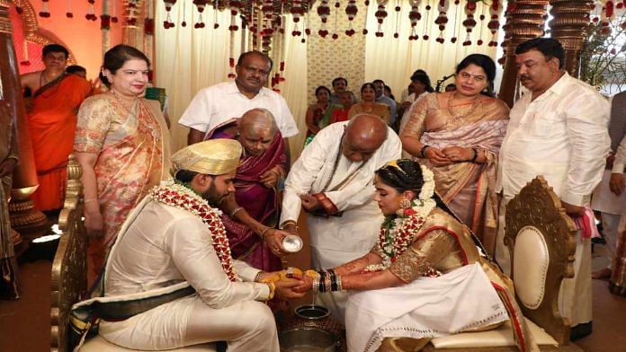 Former PM H.D. Deve Gowda and his wife bless the couple, while the parents watch on | Kumaraswamy family