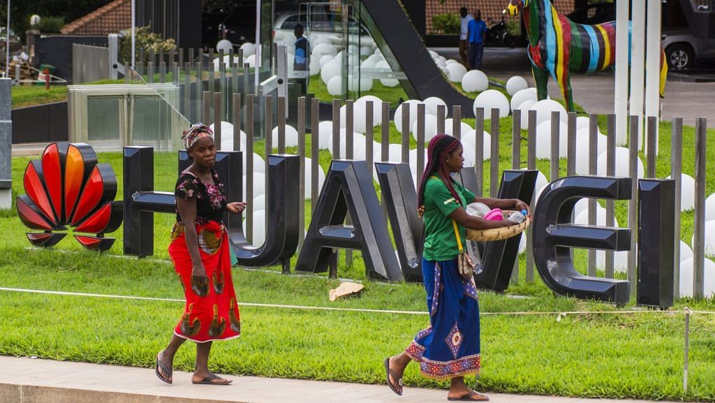 Pedestrians pass by a company logo outside the Huawei Technologies Co. offices in Lusaka, Zambia. | Bloomberg