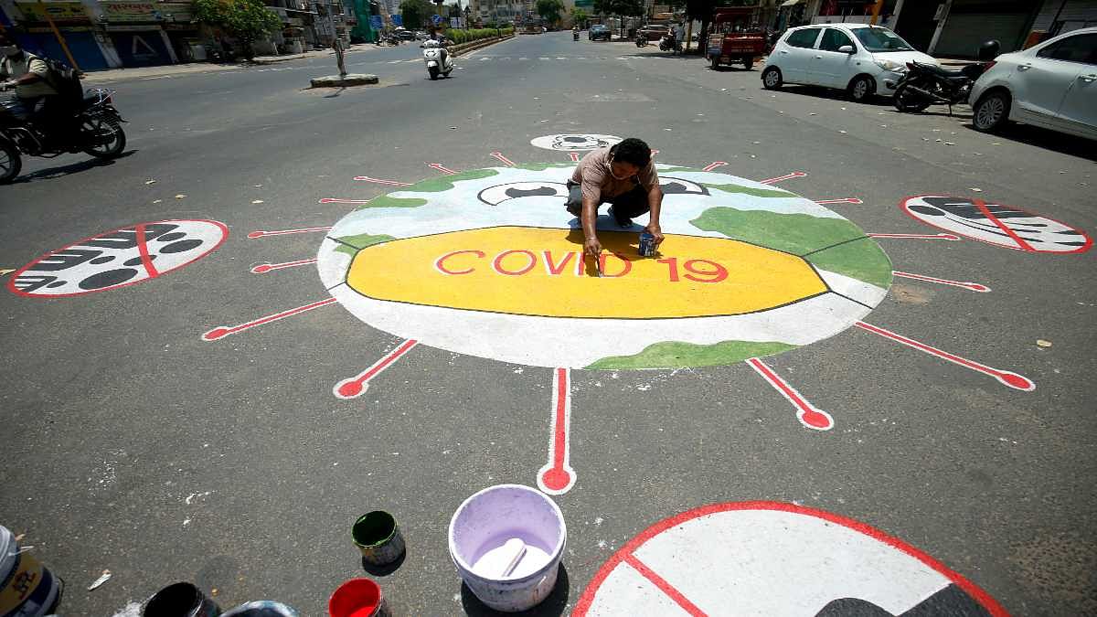 A man draws a Covid-19 awareness message on a road in Ahmedabad | Representational image | ANI