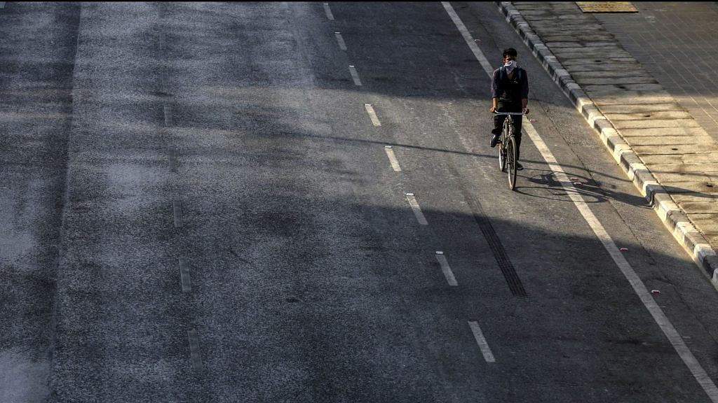 A cyclist travels on an empty street in the Marine Drive area during a lockdown imposed due to the coronavirus in Mumbai, India. | Photographer: Dhiraj Singh| Bloomberg