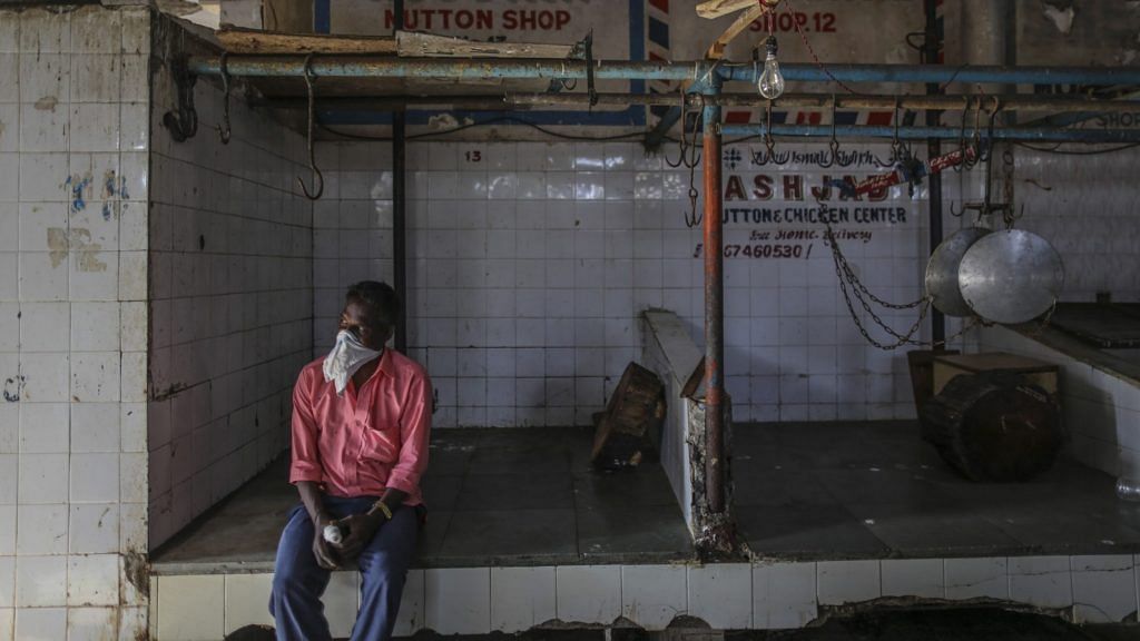 A person wears a bandana as a mask while seated in a meat shop during a lockdown imposed due to the coronavirus in Mumbai. | Photographer: Dhiraj Singh| Bloomberg