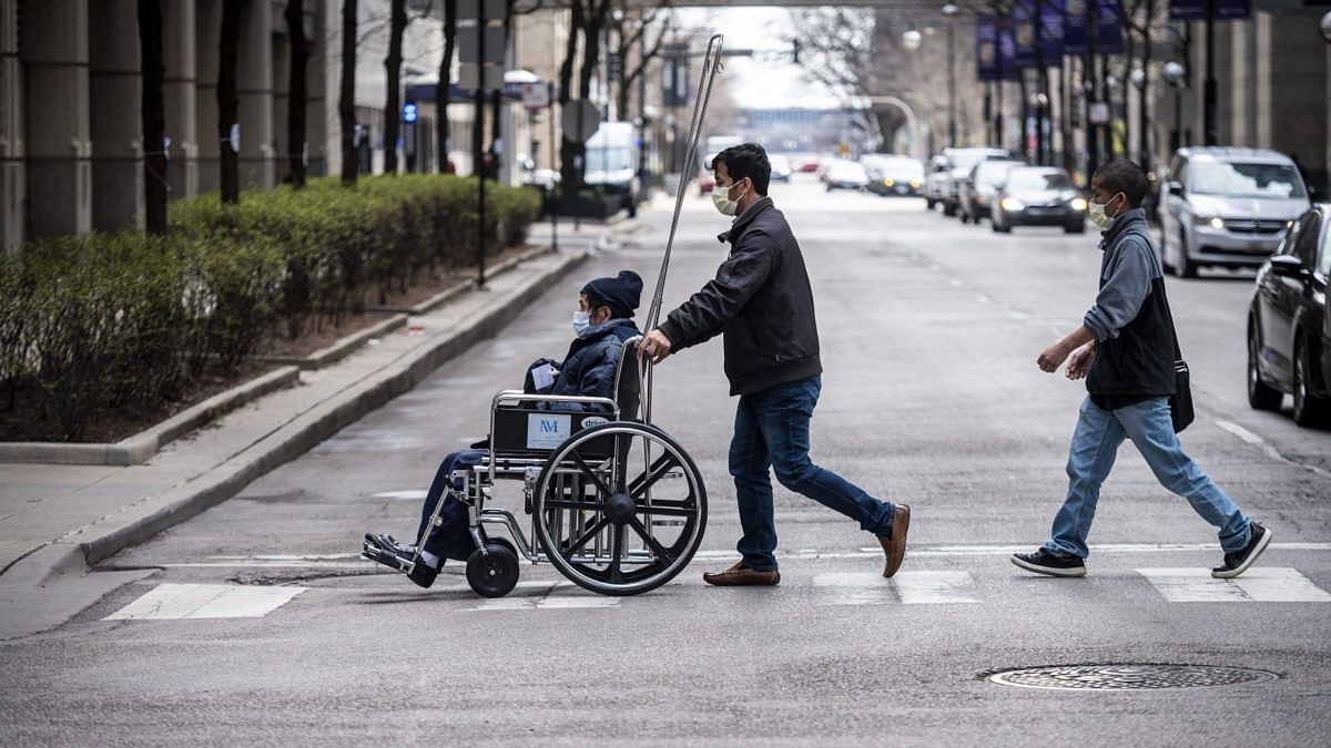Chicago Extends Stay At Home Orders As Covid-19 Peak Expected In Coming Weeks A man pushes a wheelchair towards Northwestern Memorial Hospital in Chicago, Illinois, U.S. | Photographer: Christopher Dilts | Bloomberg