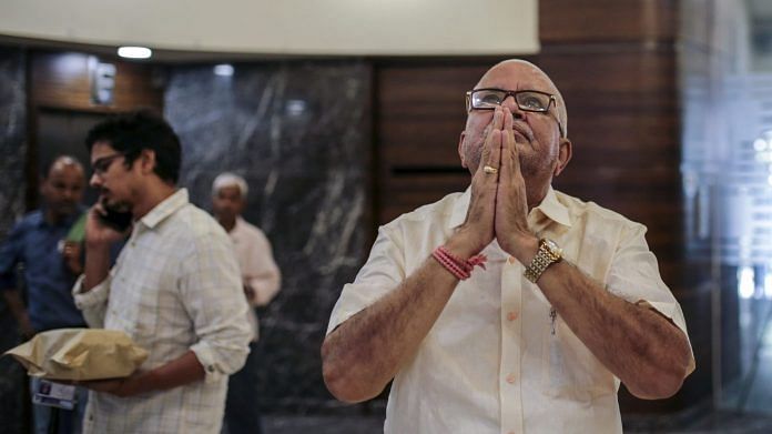 A man prays to a deity on display, not pictured, at the Bombay Stock Exchange (BSE) building in Mumbai. | Photographer: Dhiraj Singh | Bloomberg