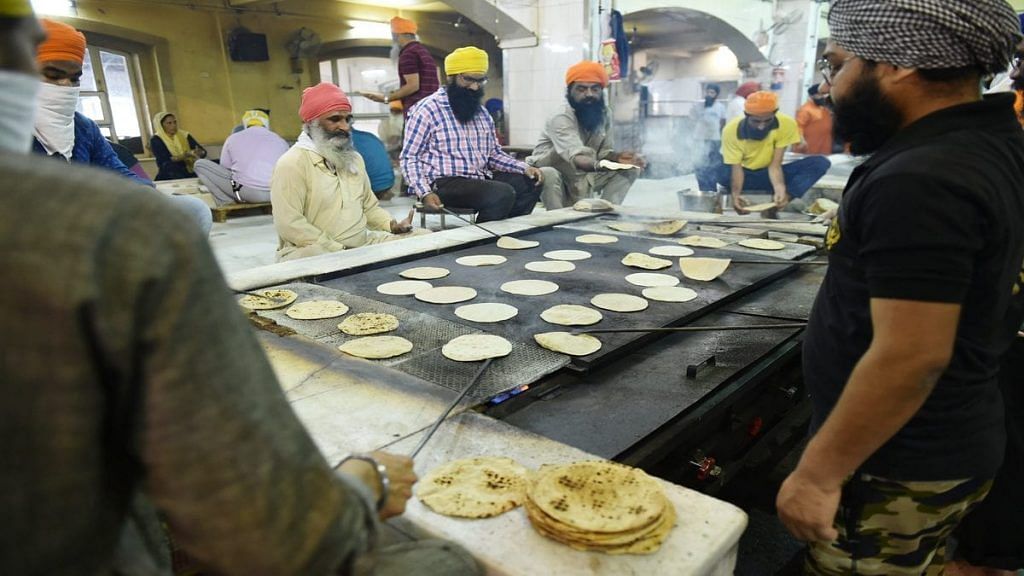 Sikh volunteers prepare meals for the needy at Bangla Sahib gurudwara in Delhi over the weekend