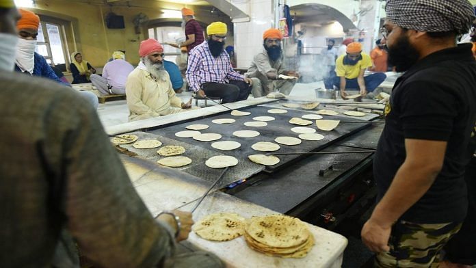 Sikh volunteers prepare meals for the needy at Bangla Sahib gurudwara in Delhi over the weekend