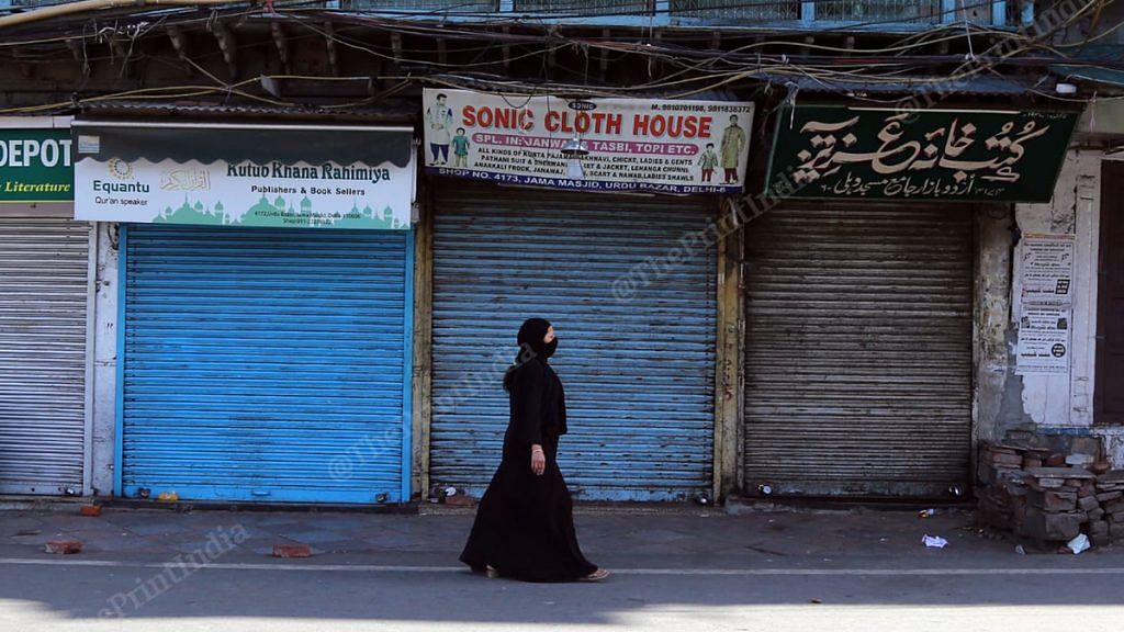 A woman walks past closed shops in Old Delhi amid the nationwide lockdown | Photo: Manisha Mondal | ThePrint