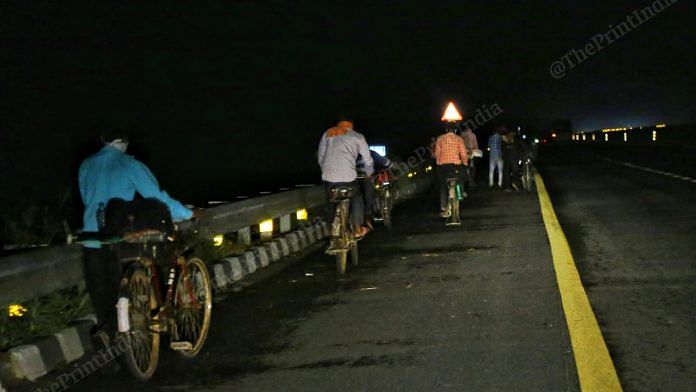 A group of men with their bicycles on the way to Uttar Pradesh in the dead of the night. | Photo: Suraj Singh Bisht/ThePrint