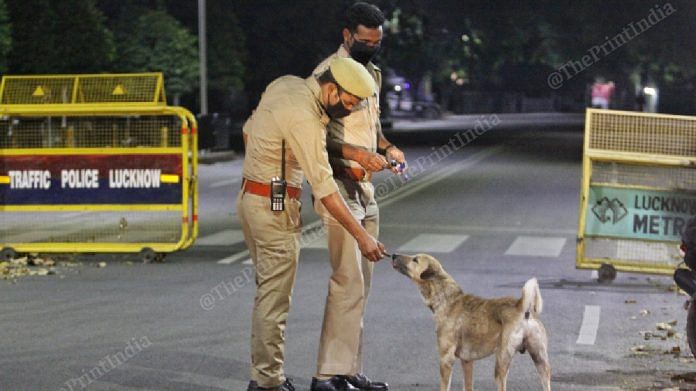 Policemen feeding stray dogs on the street. | Photo: Praveen Jain | ThePrint