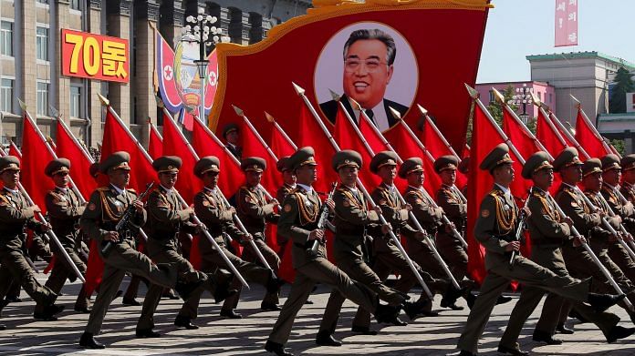 Servicemen carry a banner depicting Kim Il-sung, a former North Korean leader, during a parade in Pyongyang. | Photographer: Alexander Demianchuk/TASS/Getty Images | Bloomberg