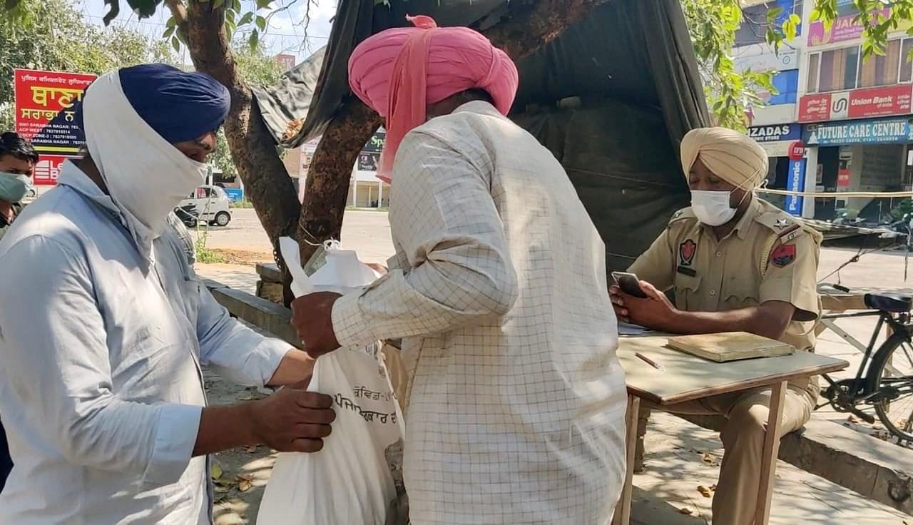 ASI Kulwant Singh distributing dry ration opposite Sarabha Nagar police station in Ludhiana. | Photo: Urjita Bhardwaj/ThePrint 