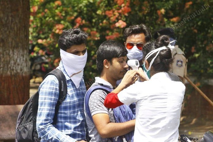 A medic checks body temperature, an indicator of whether a person has the Covid-19 infection, in Gandhinagar | Praveen Jain | ThePrint