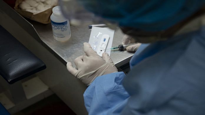 A medical worker puts blood sample in a kit for rapid blood test | Representational Image | Carlos Becerra | Bloomberg