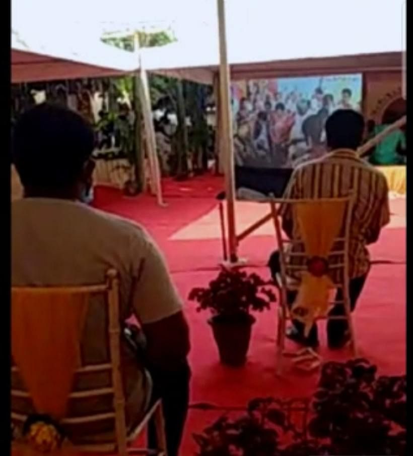 Guests, seated at a distance from each other, watch the wedding on a giant screen | Screenshot from video released by Kumaraswamy family 