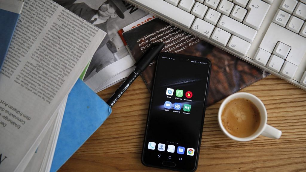 A smartphone sits next to a cup of espresso on the desk of a home office in an arranged photograph taken in Bern, Switzerland. (Representational Image) | Photographer: Stefan Wermuth | Bloomberg
