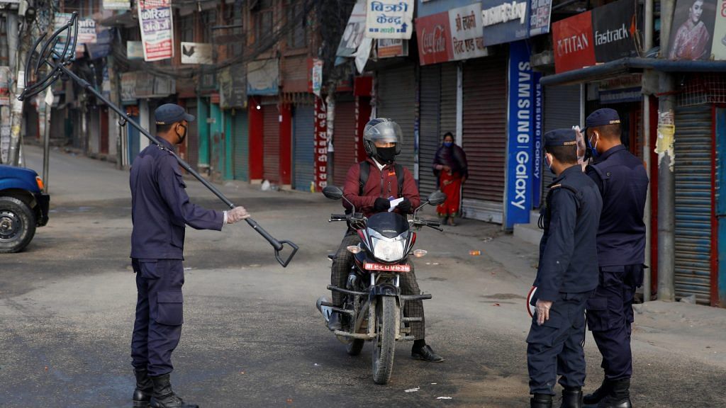 Nepalese police officers interrogate a man on a motorbike during the sixth day of the lockdown imposed by the government amid concerns about the spread of coronavirus disease (COVID-19) outbreak, in Kathmandu, Nepal on Sunday. | ANI