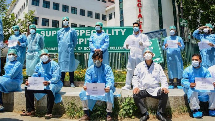 Srinagar: Senior doctors at Super Speciality Hospital, Srinagar display placards during a protest against alleged manhandling of two senior doctors by the police while they were duty, during ongoing COVID-19 lockdown, in Srinagar, Tuesday, May 26, 2020. (PTI Photo)