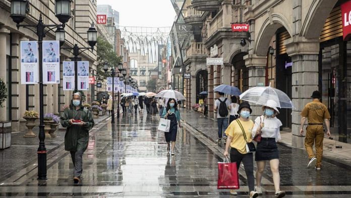 (Representational Image) walk with umbrellas past stores in Wuhan on 30 April | Photo: Qilai Shen | Bloomberg