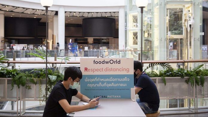 Social distancing barriers divide people sitting in the newly re-opened Central Food Mall in Bangkok on May 11 | Bloomberg
