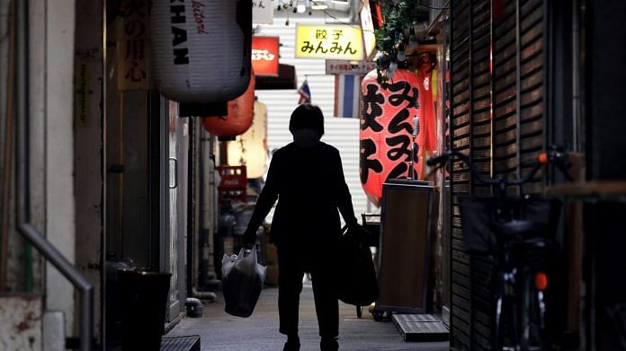 A shoper walks through an alley in the Kichijoji area of Tokyo on May 26. | Bloomberg