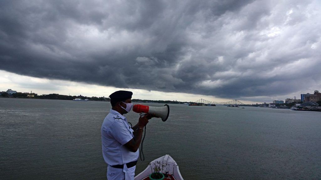 A Kolkata policeman makes a security announcement as dark clouds gather over the city Tuesday, a day before Amphan is supposed to make landfall | ANI
