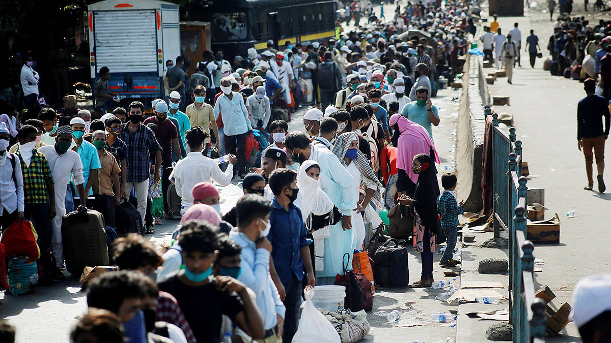 Migrant labourers in line to board a bus in Mumbai's Dharavi to railway station Tuesday | PTI