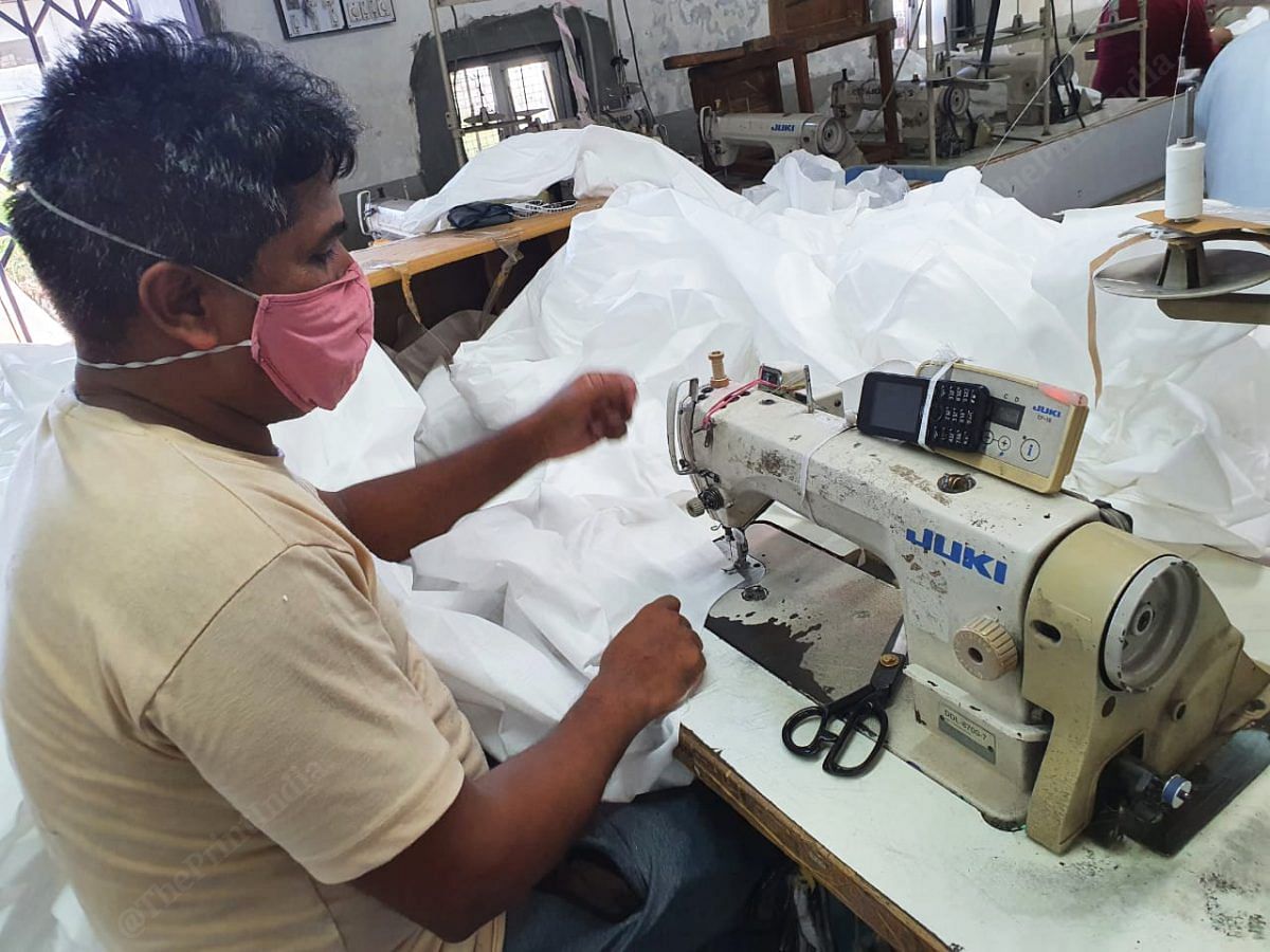 Once the stitching is done, the overall is sent to another team for inspection. Here the team looks for any loose threads or knots that they can trim out. Any spots on the cloth are also sanitised and cleaned | Photo: Soniya Agarwal | ThePrint