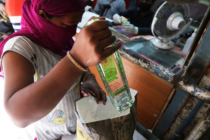 A woman put a bottle of alcohol inside the bag | Photo: Manisha Mondal | ThePrint