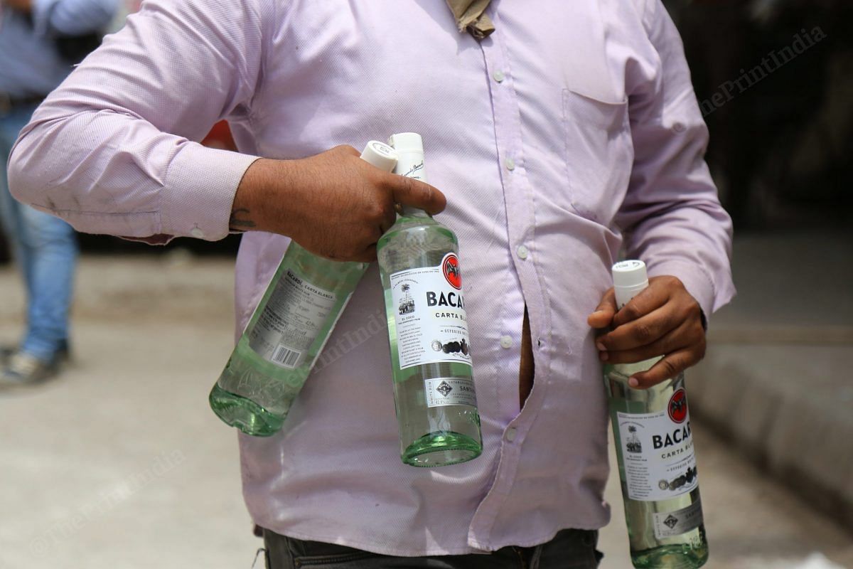 People carry boxes of alcohol in Paharganj | Photo: Manisha Mondal | ThePrint 