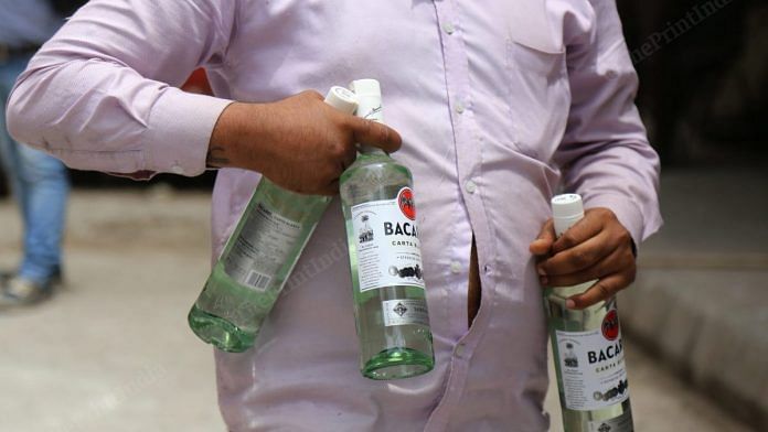 People carry boxes of alcohol in Paharganj | Photo: Manisha Mondal | ThePrint