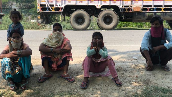 A family of migrant workers waiting along the Lucknow-Hardoi-Shahjahanpur highway in UP | Photo: Jyoti Yadav | ThePrint