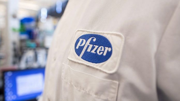 The Pfizer logo on the lab coat of an employee at the company's research and development facility in Cambridge, Massachusetts. | Bloomberg