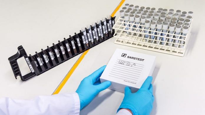 A lab worker boxes up test tubes of patient samples in a virology research labs | Geert Vanden Wijngaert | Bloomberg