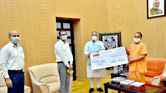 Urban Development Minister Ashutosh Tandon handing over the cheque to Chief Minister Yogi Adityanath. Also seen is Jal Nigam MD Vikas Gothalwal (centre)  | Twitter: @myogioffice